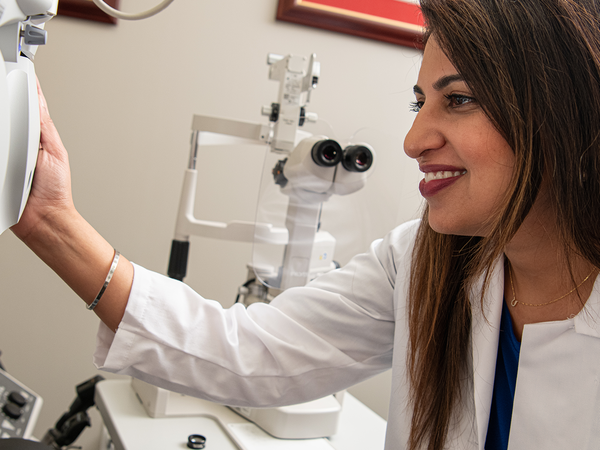 Woman using machine to look in patients eyes