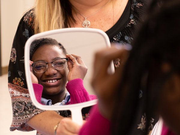 Child trying on glasses in a mirror