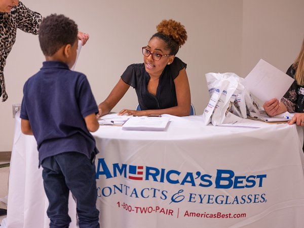 An America's Best employee helping a child