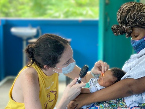Young woman checking baby's eyes