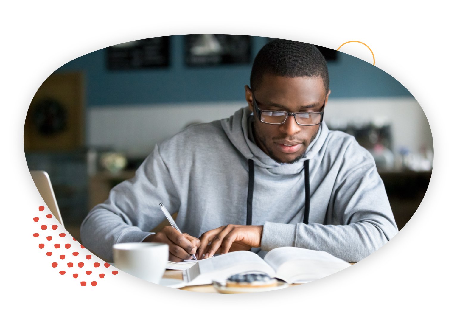 African American male wearing glasses and working on his studies at a coffee shop.